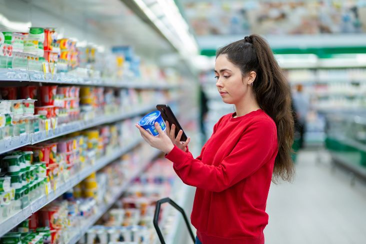 Shopping woman scanning ingredients from yogurt