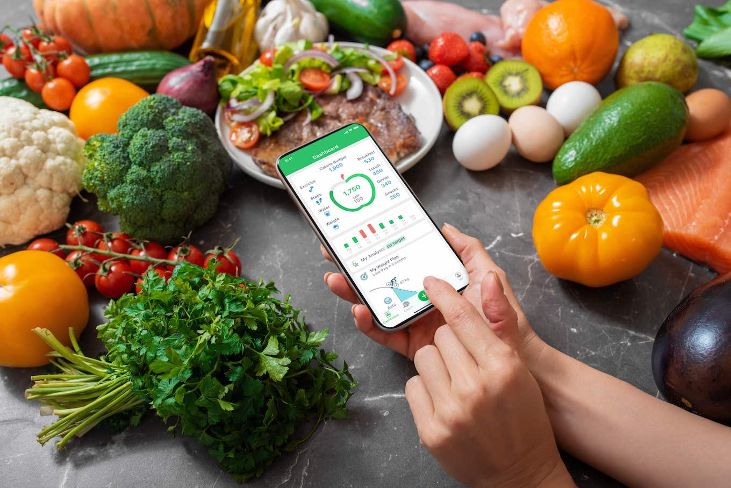 MyNetDiary dashboard with fresh vegetables on a kitchen counter.
